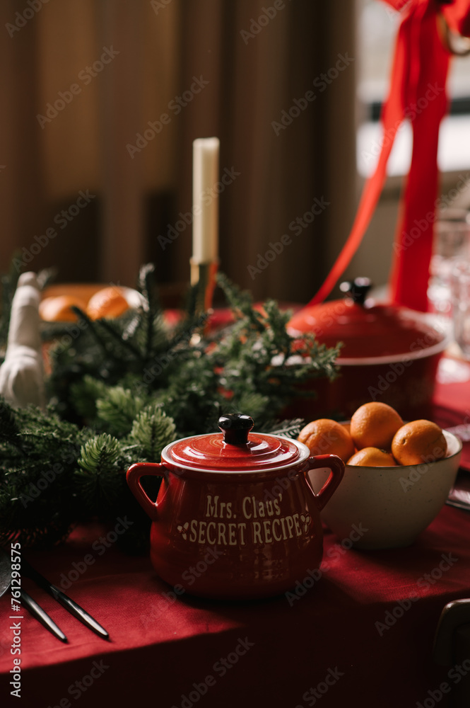 Beautiful New Year decor, a Christmas table with a red tablecloth and candles, festive dishes and glasses