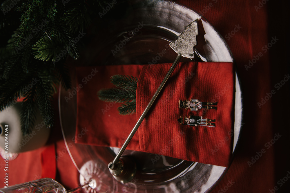 Beautiful New Year decor, a Christmas table with a red tablecloth and candles, festive dishes and glasses