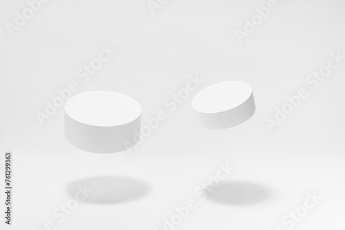 Set of two round tilt white podiums for cosmetic products mockup  soar in hard light  shadow on white background. Stage for presentation skin care products  gifts  goods  advertising  design  sale.