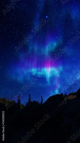 Aurora borealis on starry sky over mountain peaks with tree sihouettes, panning vertical video photo