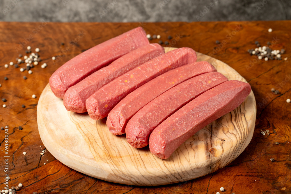 Raw sausage. Butcher products. Sausages made from uncooked beef on a dark background. Close up Raw sausage. Butcher products. Sausages made from uncooked beef on a dark background. Close up
