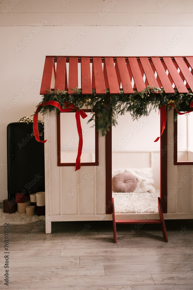 Beautiful stylish modern interior of a children's room with a wooden bed and a toy decorated for the new year
