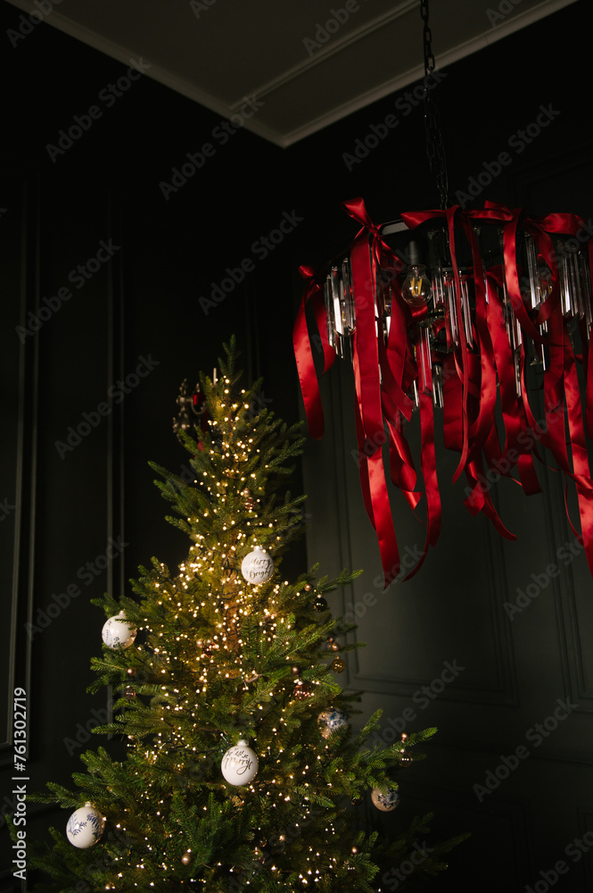 Beautiful New Year decor, Christmas tree in the stylish dark interior of the living room