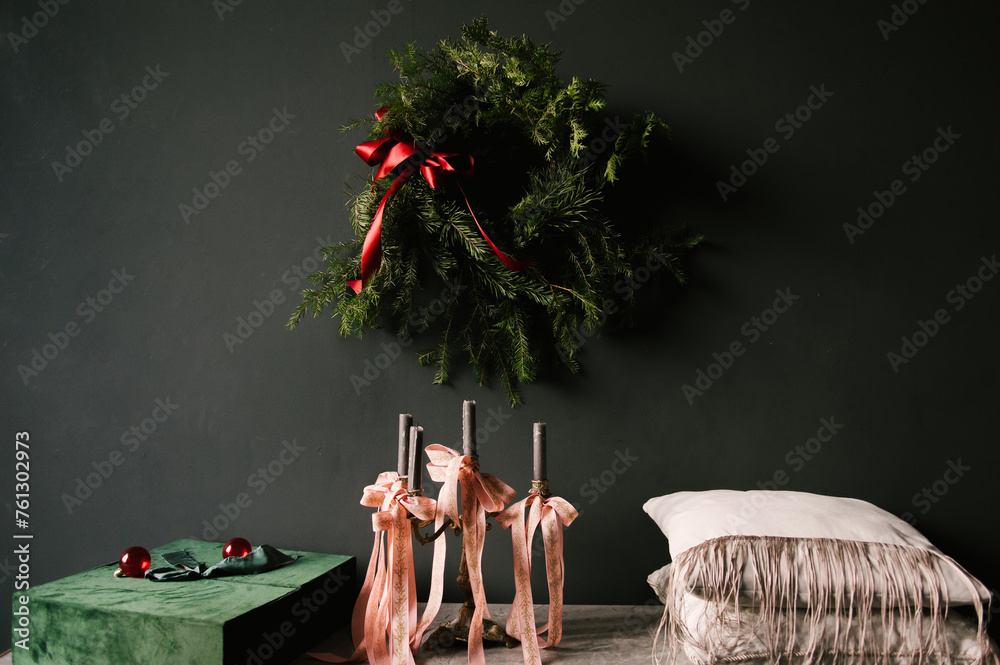 Beautiful New Year decor, a Christmas wreath on a vintage chest of drawers in a stylish dark living room interior