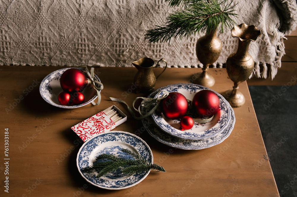 Beautiful New Year decor, red balls in vintage plates and gold candlesticks