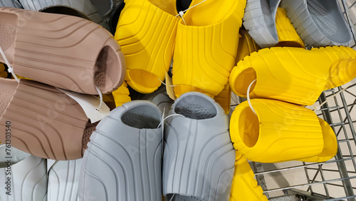 Different slipper shoes are in the basket in the store