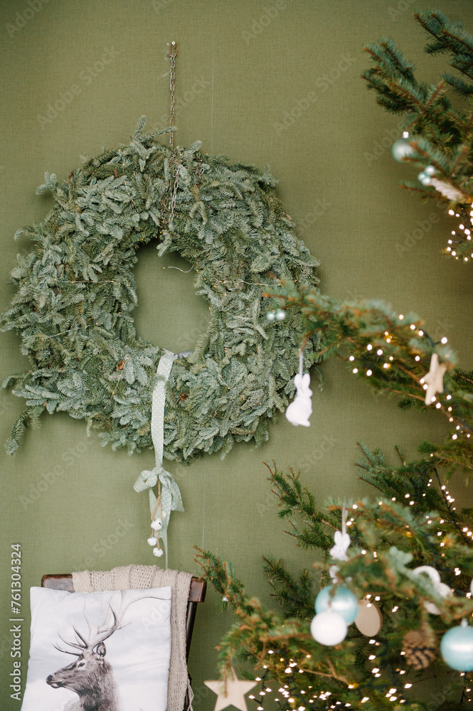 Beautiful New Year decor in a stylish interior with a Christmas tree, wreath and gifts