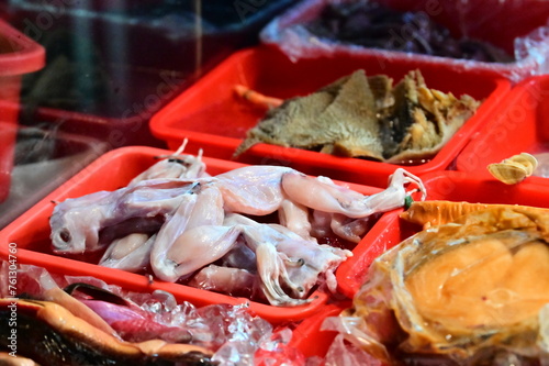 Close-up of a processed but uncooked frog at a stir-fry stall in Nanjichang Night Market, which is known for its long history, affordable food, and diverse selection of options. photo