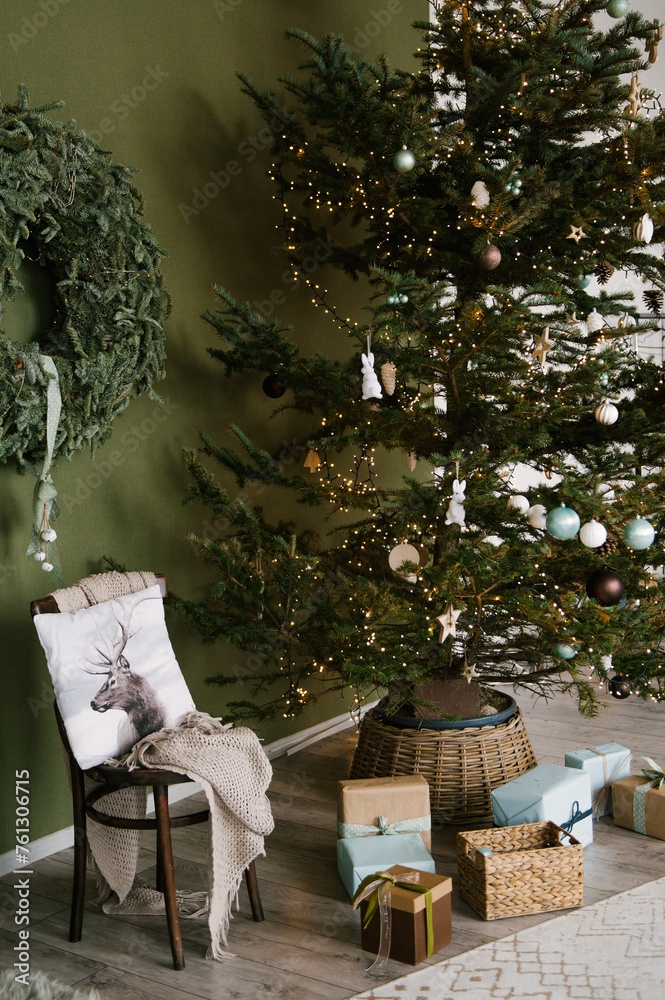 Beautiful New Year decor in a stylish interior with a Christmas tree, wreath and gifts