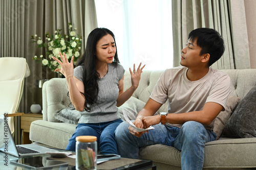 Stressed couple quarreling, arguing about serious financial problems at home