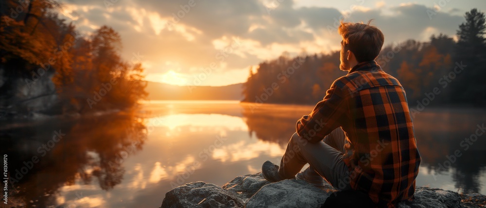 Fototapeta premium Backpacker contemplates a calm lake surrounded by autumnal mountain scenery, symbolizing a journey of adventure, hiking, and connection with nature