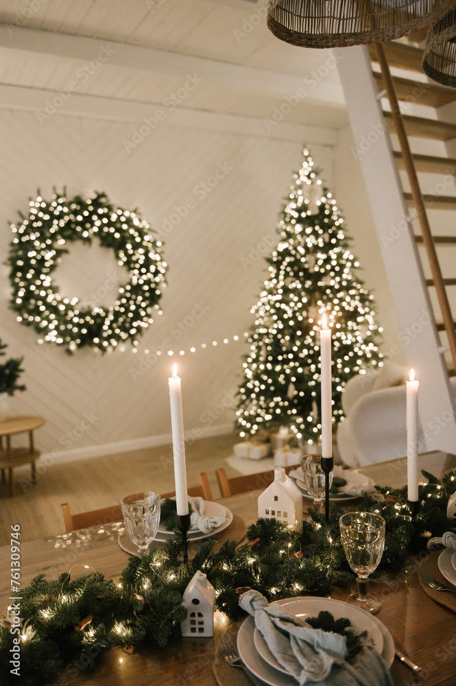 Beautiful New Year's decor at home, the table is set for the holiday against the background of the lights of the Christmas tree