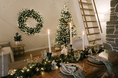 Beautiful New Year's decor at home, the table is set for the holiday against the background of the lights of the Christmas tree