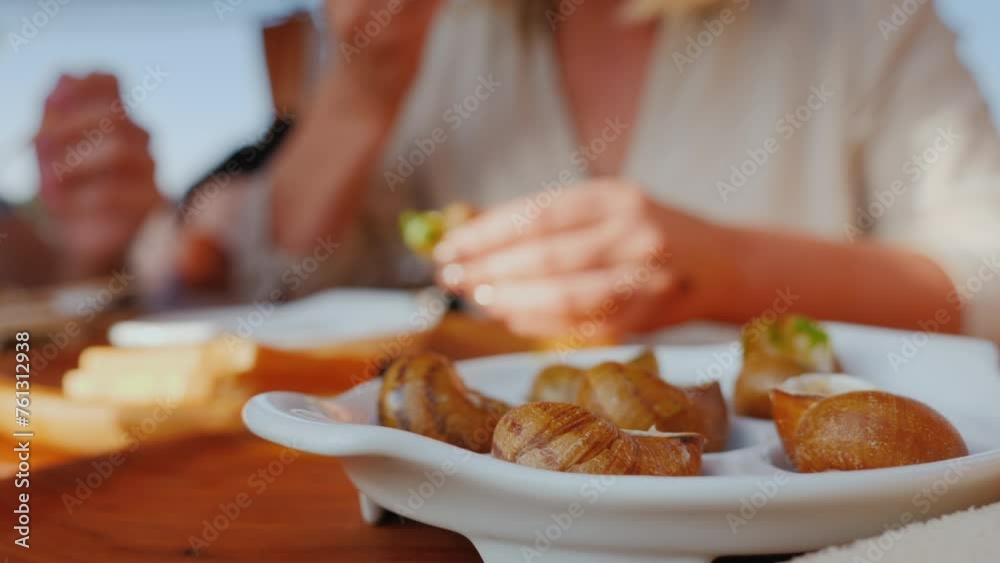 Tourists taste snails - an exquisite dish of French cuisine