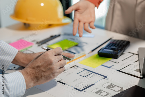 An engineer and an architect exchange information about a building they are about to build together in a private office, Discuss designs together for perfect work before present to the customer.