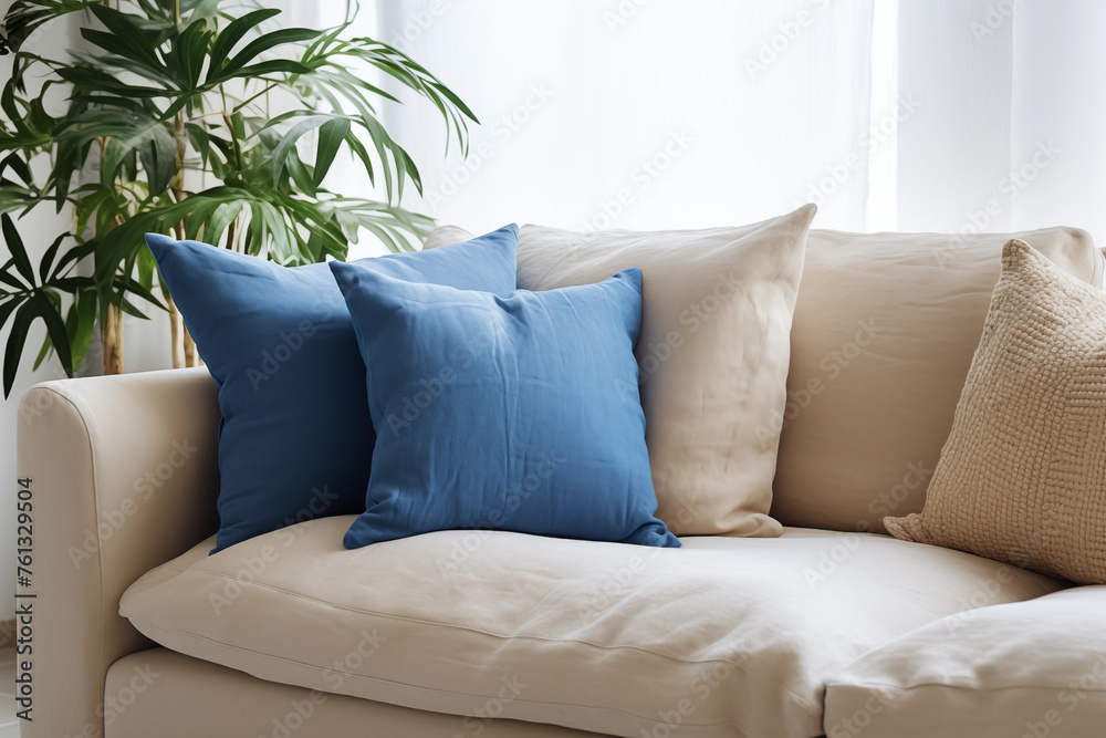 Salon avec un canapé beige et coussin bleu, zoom avec une plante Salon avec un canapé beige et coussin bleu, zoom avec une plante