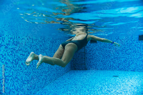 Underwater photo  girl swimming in a spa pool  side view.