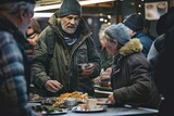 A positive homeless white man stands in front of a table filled with food in a street dining hall, surrounded by other individuals