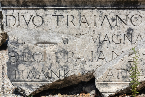 Ancient Roman Greek inscription tribute (text is name and title of 'blessed Emperor Trajan' in Latin language), Perge lapidarium, high contrast, weathered texture. Aksu, Antalya, Turkey (Turkiye) photo