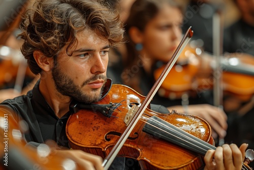 An orchestra, led by a passionate violinist, delivers a beautiful oncert. photo