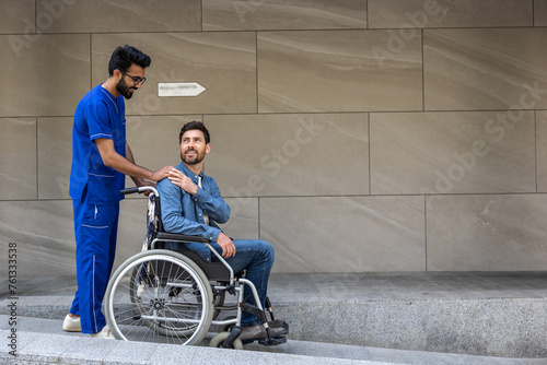 Dark-haired male nurse taking a patient in wheelchair for a walk