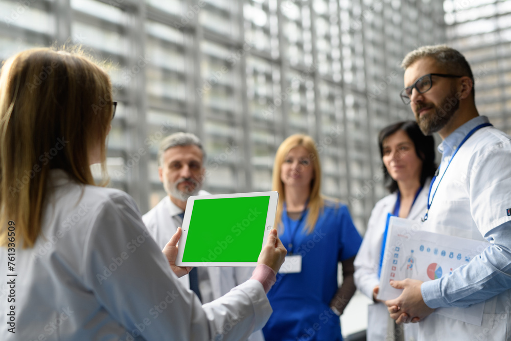 Group of doctors discussing test results, looking on tablet, medical team discussing patients diagnosis, searchign for right treatment. Group of doctors discussing test results, looking on tablet, medical team discussing patients diagnosis, searchign for right treatment.