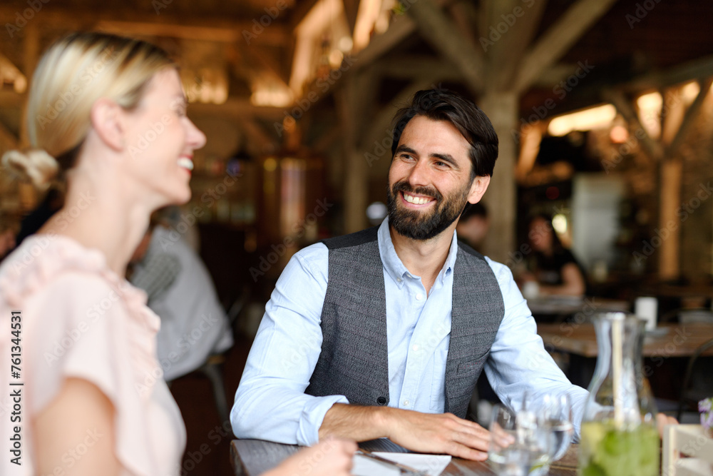 Happy loving couple at date in restaurant. Husband and wife sitting at table, laughing, having lunch in modern cafe. Happy loving couple at date in restaurant. Husband and wife sitting at table, laughing, having lunch in modern cafe.