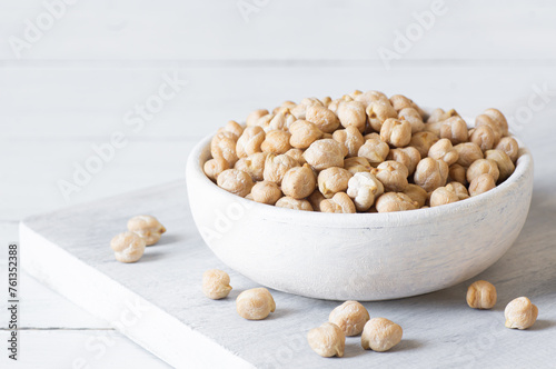 Uncooked dried chickpeas in bowl or spoon on table. Heap of legume chickpea background