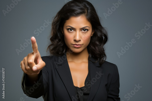 Woman in black suit is pointing her finger at camera