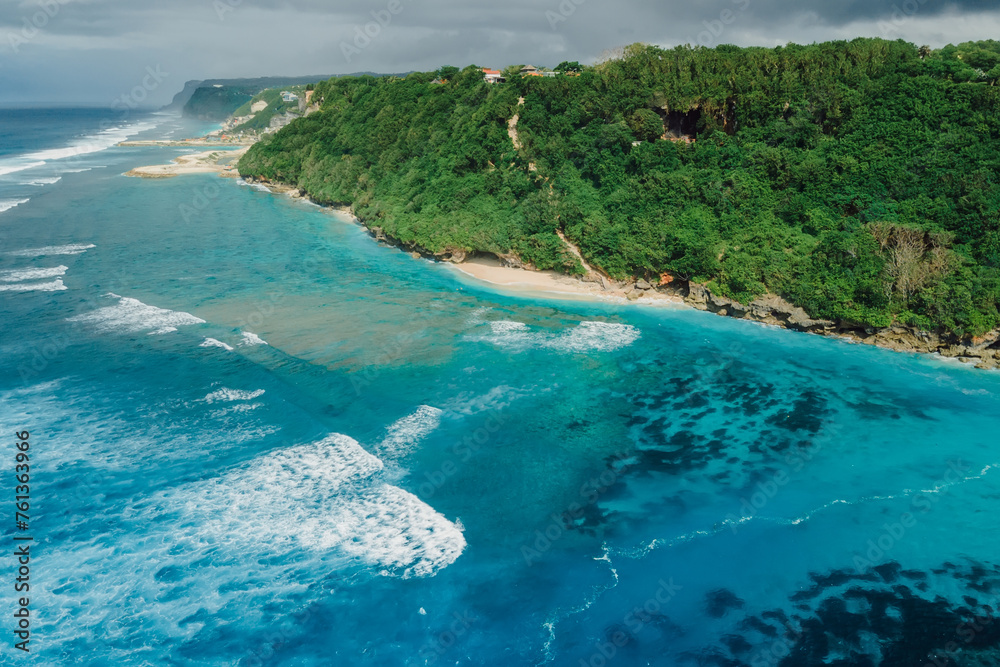 Beach coastline with turquoise ocean and waves in Bali. Aerial view