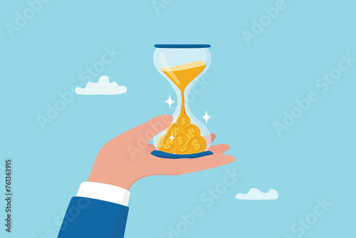 Time is money, long term investment to gain profit earning, interest rate return from savings, salary growth or wage increase concept, businessman hand holding hourglass with sand falling to money. © Nuthawut