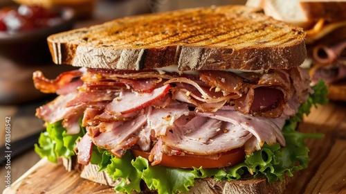 Sandwich with bacon, lettuce, and tomato on wooden board
