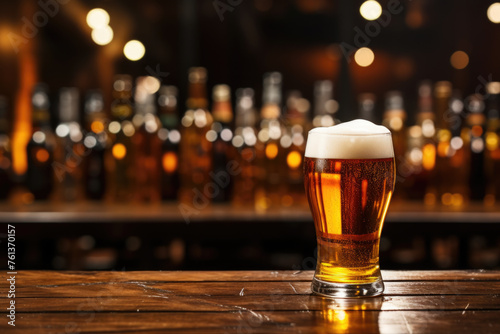 Glass of beer sits on wooden bar counter