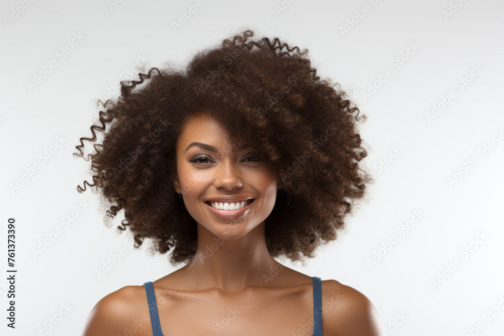 Woman with curly hair is smiling and looking at camera Woman with curly hair is smiling and looking at camera