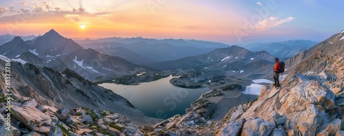 lone hiker stands on rocky summit with lakes and mountains, sunrise