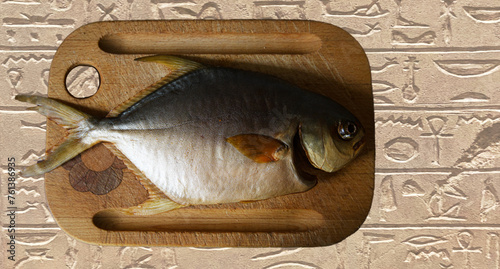 Wędzona ryba na drewnianej desce do krojenia. Egipskie hieroglify. Przezroczyste tło. © YOUR SHOT