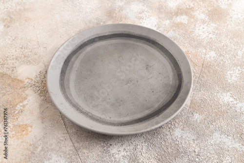 Empty gray ceramic plate on gray concrete background. Side view, copy space