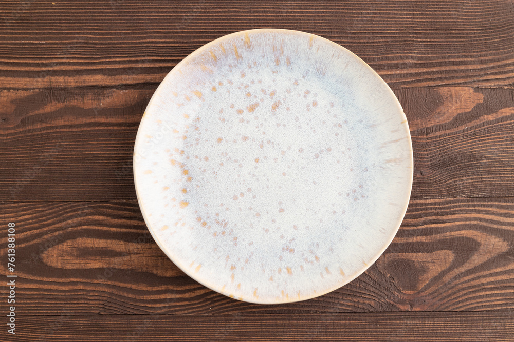 Empty blue and gold ceramic plate on brown wooden. Top view, copy space Empty blue and gold ceramic plate on brown wooden. Top view, copy space