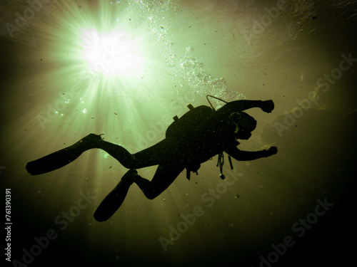 A local scuba instructor is backlit by a sunburst sky through the yellowish-green waters at Troy Springs State Park, Florida © Erin Westgate