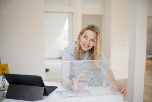 beautiful woman, architect, business woman with blond hair and grey shirt working on transparent tablet, standing table, modern office, loft