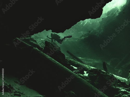 A local woman scuba diver is backlit in the green waters at Troy Springs State Park, Florida