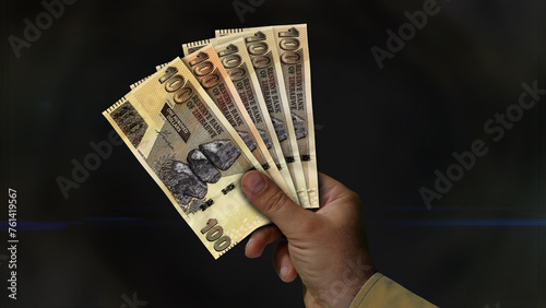 Zimbabwe Dollar growing pile of money in hand concept 3d illustration photo