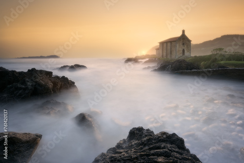 calm waves in the Cantabrian Sea in a warm dawn in front of the hermitage of Santa Katalina in Mundaka © patxi