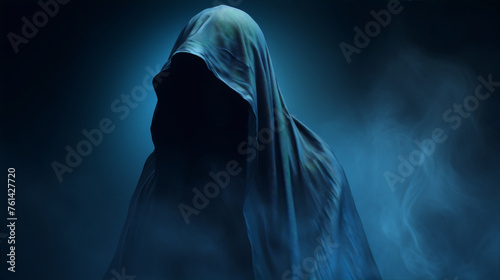 Dark figure in a cloak with a mysterious blue fog surrounding it. photo