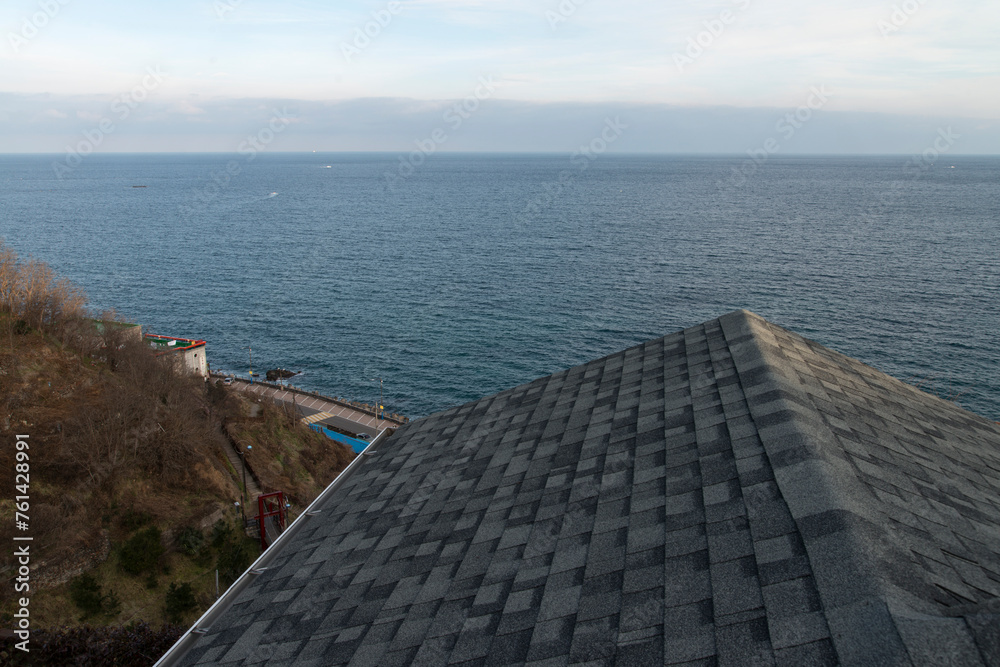 View of the tiled roof against the sea and horizon