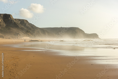 Cordoama Beach in Portugal. Atlantic Ocean and rocky cliffs at sandy beach photo