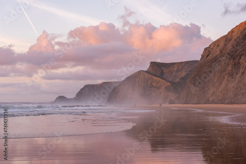 Sunset at Cordoama Beach in Portugal. Atlantic Ocean and rocky cliffs at sandy beach