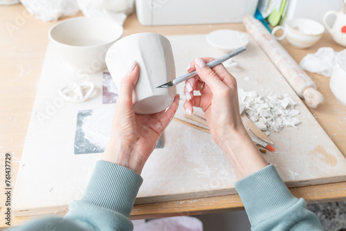Close-up Image of female hands working with clay mug and making Ceramic Product. Professional Ceramic Artist makes handcrafted products. Small business and hobby concept