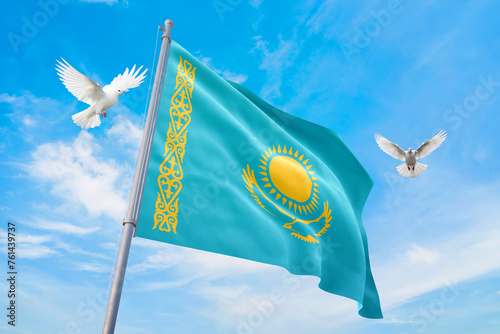 Waving flag of Kazakhstan in beautiful sky and flying pigeons. Kazakhstan flag for independence day. The symbol of the state on wavy fabric.