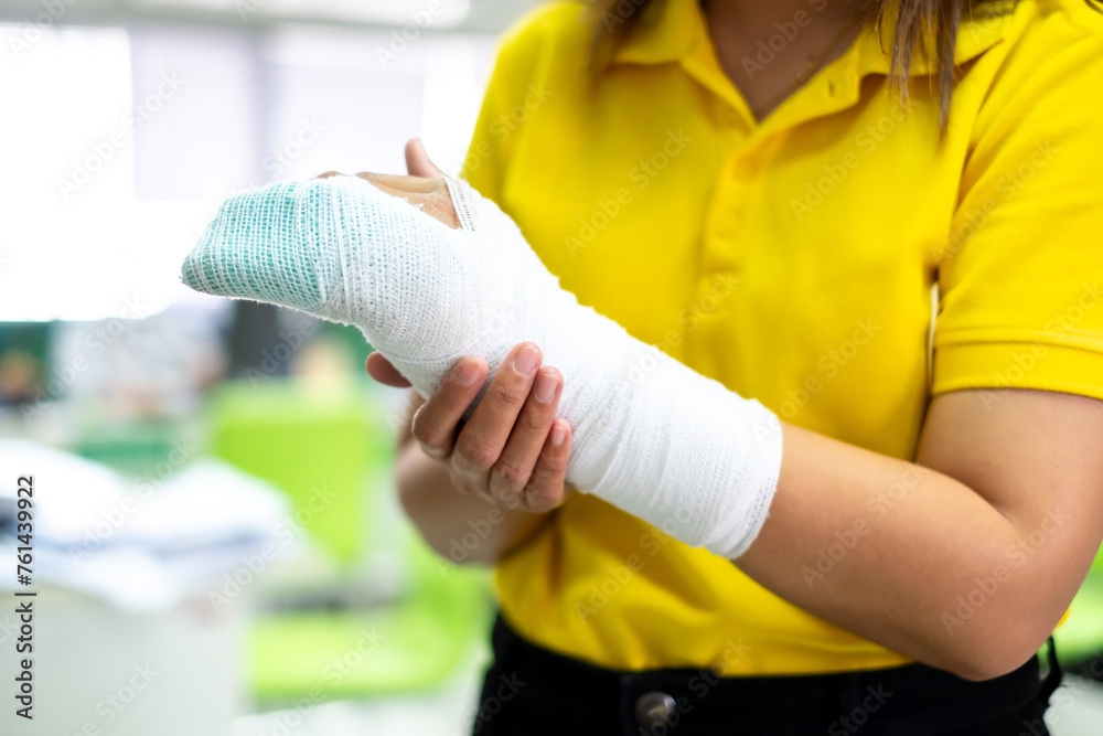 Woman's hand wrapped in white bandage from accident, injury, accident insurance, soft splint on finger, copy space